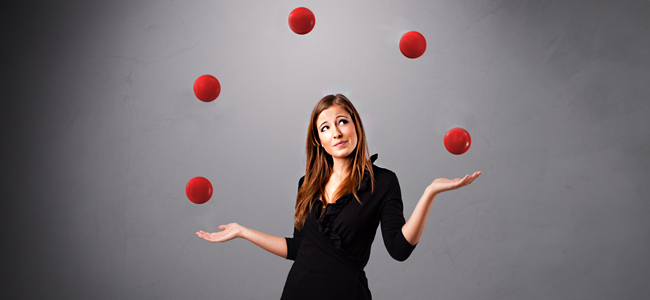 young girl standing and juggling with red balls